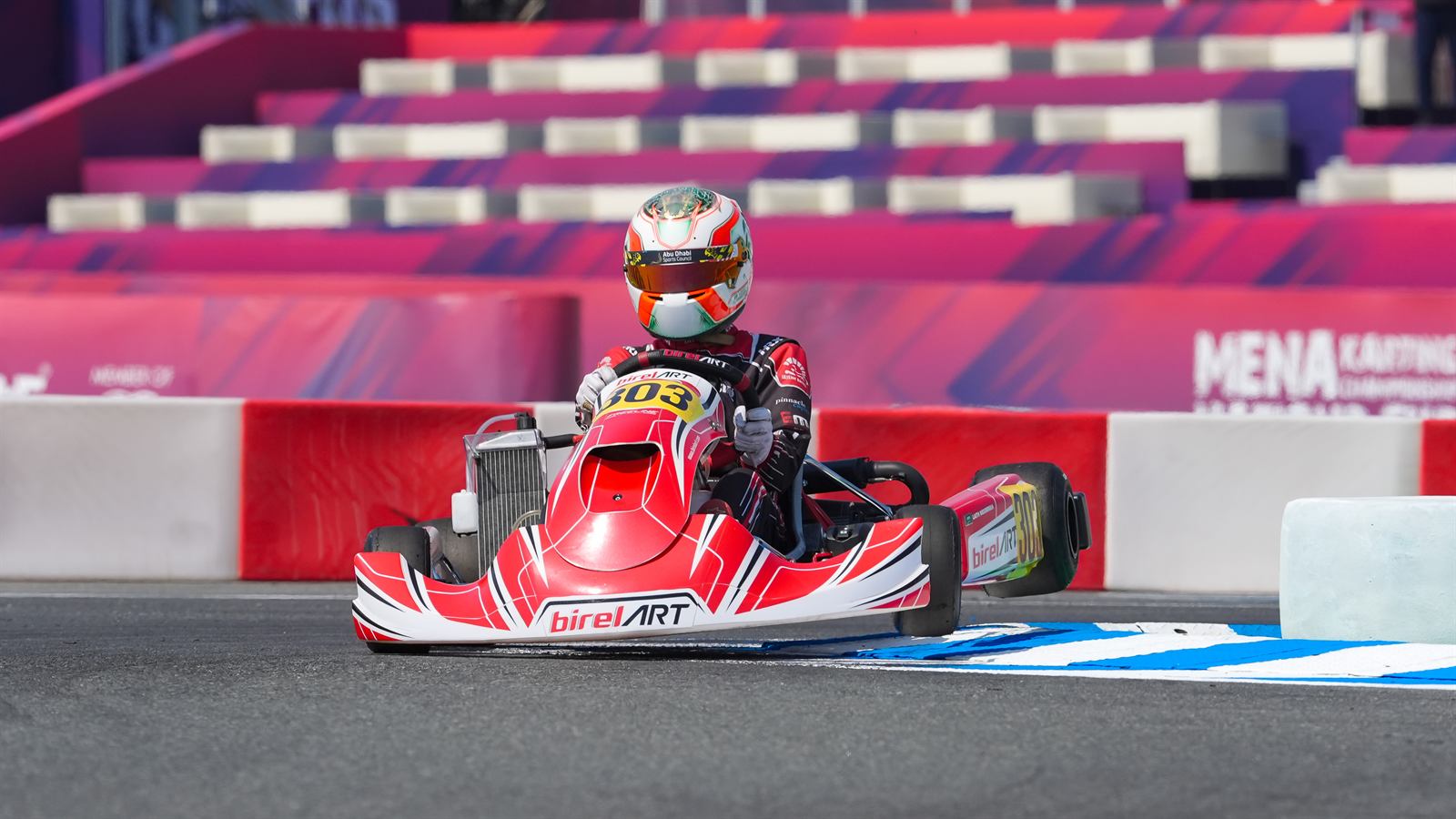 Kart driver exiting a corner on a race circuit
